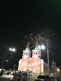 Illuminated street amidst buildings in city at night