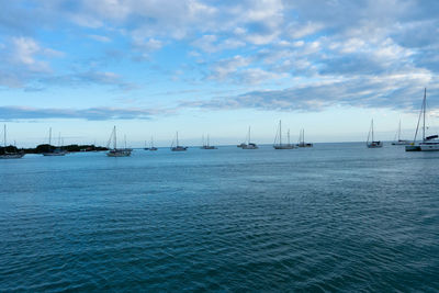 Sailboats in sea against sky