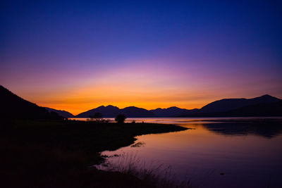 Scenic view of lake against orange sky