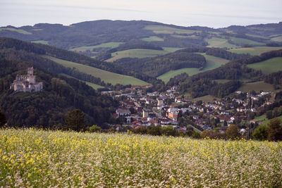 High angle view of townscape by field against sky