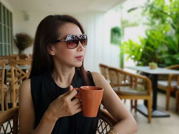 Mature woman with coffee cup sitting in cafe