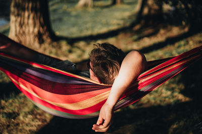 Midsection of young woman sitting on hammock