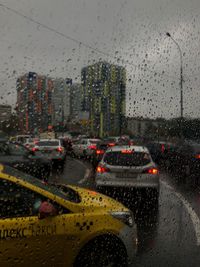 City seen through wet glass window during rainy season