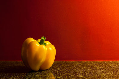 Close-up of bell peppers on table against wall
