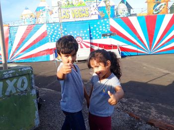 Siblings standing against wall