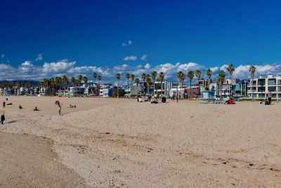 Panoramic view of people on beach against blue sky