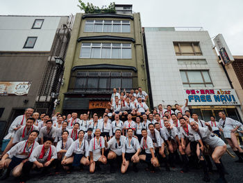 People standing on street against buildings in city