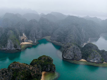 High angle view of lake and mountains against sky