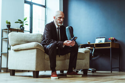 Full length of businessman using mobile phone