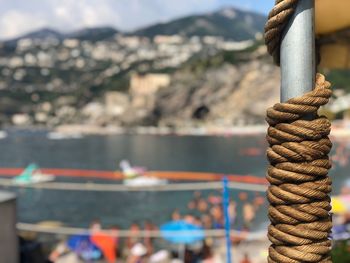 Close-up of rope against bridge over sea