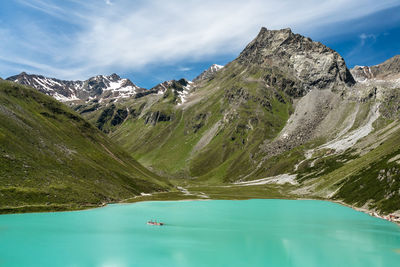 Scenic view of lake by mountains against sky