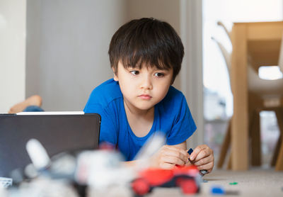 Portrait of boy using mobile phone at home