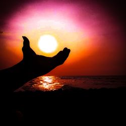 Silhouette person on beach against sky during sunset