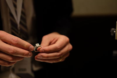 Midsection of bridegroom holding wedding ring