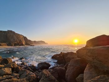 Scenic view of sea against clear sky during sunset