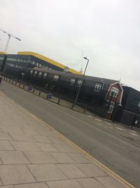 People at railroad station against sky