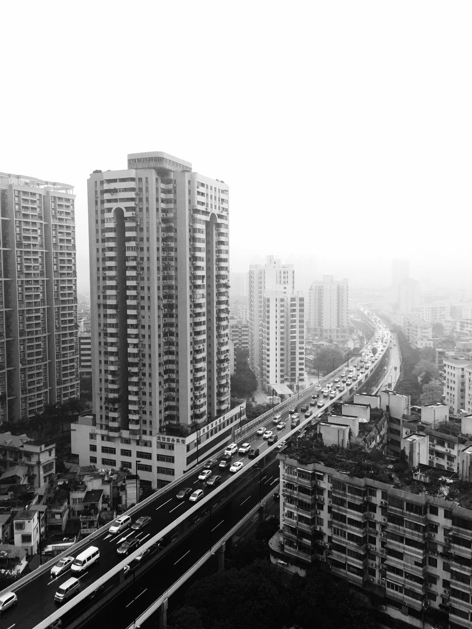 building exterior, architecture, built structure, clear sky, city, copy space, transportation, high angle view, car, cityscape, road, street, city life, land vehicle, building, mode of transport, residential building, residential structure, outdoors, day