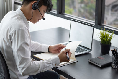 Man using mobile phone while sitting on table