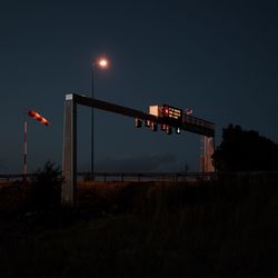 Information sign against clear sky at night