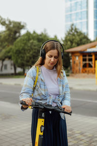 Portrait of young woman standing in city