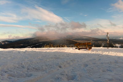 Scenic view of snow covered field against sky