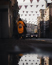 Rear view of woman walking on street in city