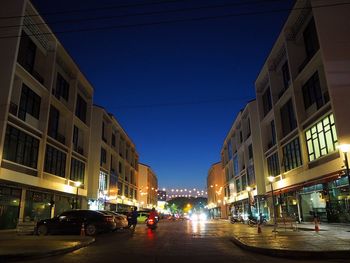 City street amidst buildings at night