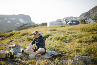 Woman camping, camping site in background