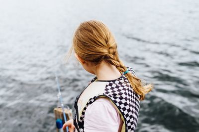 Rear view of woman standing against sea