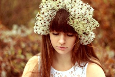 Sad young woman with flowers and bangs