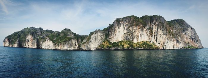 Panoramic view of rock formation in sea against sky