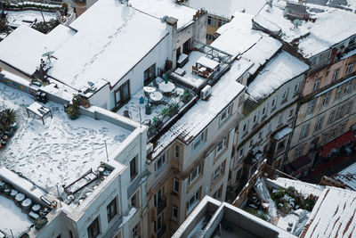 High angle view of rooftops covered in snow in city