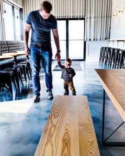 Full length of father and son walking on floor