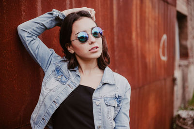 Portrait of young woman wearing sunglasses standing outdoors