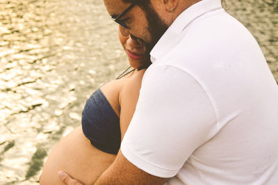 Couple embracing while standing at lake