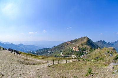 Scenic view of landscape and mountains against blue sky