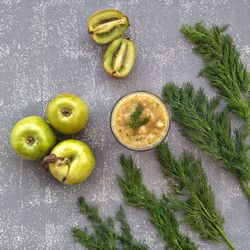 High angle view of juice with fruits and dill on table