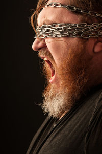 Close-up portrait of man against black background