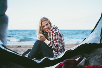 Portrait of woman sitting at beach