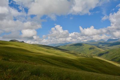 Scenic view of green landscape against sky