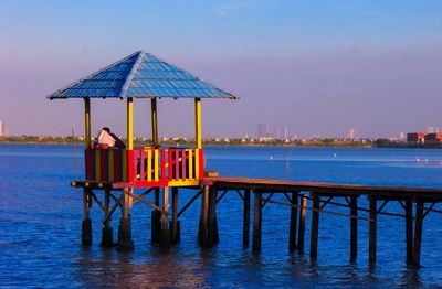 Gazebo by sea against blue sky