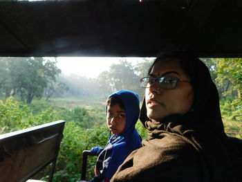 Portrait of young man and woman looking through window