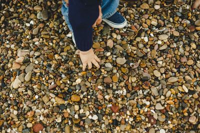 Low section of person standing on pebbles