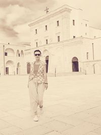 Portrait of man standing against historic building