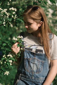 Cheerful woman standing against plants