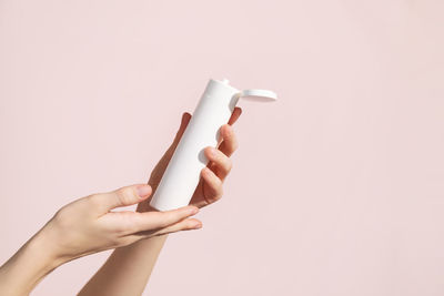 Young female hands holding blank white squeeze bottle plastic tube. mockup.