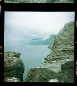 Scenic view of sea and mountains against sky