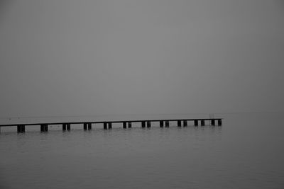 Pier on sea against clear sky