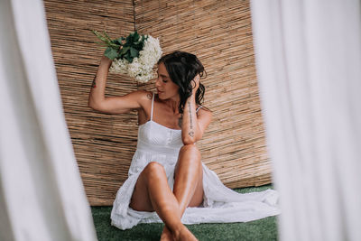 Midsection of woman holding white flowers