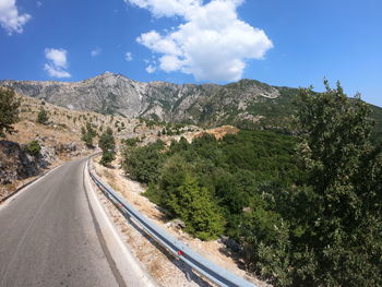 Road leading towards mountains against sky